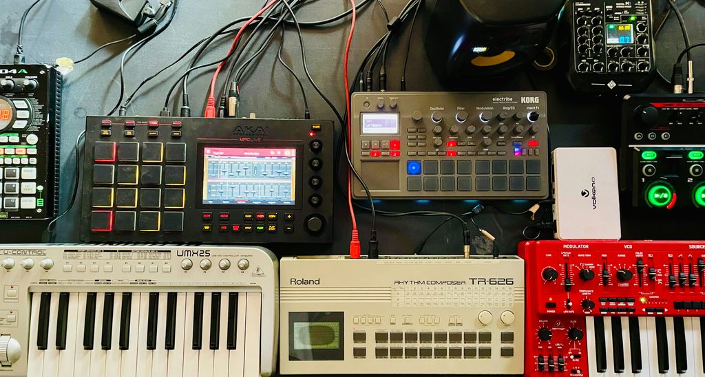 Home studio équipé de machines de production musicale anciennes, rappelant les méthodes de création du boom bap et l’âge d’or du sampling.